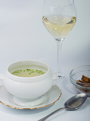 Ceramic soup tureen with consomm&eacute;, accompanied by a plate of toasted bread.