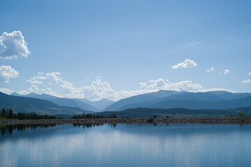 Lake Dillion under a bright sky with reflection of mountains.
