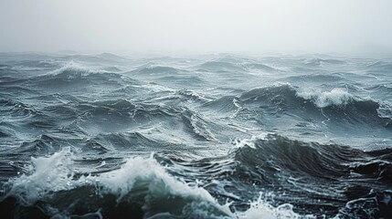 Fototapeta premium Moody ocean waves under a misty sky, capturing the power and tranquility of the sea. The gray tones and mist create a serene yet dramatic atmosphere. 