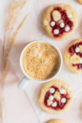 Overhead view of a coffee cup and strawberry cookies