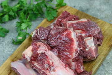 Iga sapi mentah or raw beef ribs  on preparation for cooking with some spice. Beef ribs on chopping board with wooden rustic background.