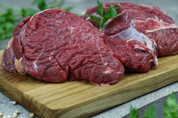 Daging sapi mentah or raw beef on preparation for cooking with some spice. Beef on Eco friendly package and chopping board with wooden rustic background.