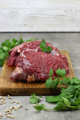 Daging sapi mentah or raw beef on preparation for cooking with some spice. Beef on Eco friendly package and chopping board with wooden rustic background.