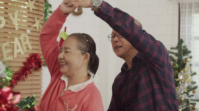 Happy Asian family spending times to prepare Chritsmas and Happy news year Celebrete. kids parent and grandparent doing ginger breads and bakery enjoy and dancing in kichen at home
