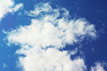 white cloud against a blue sky, illuminated by the sun from one side