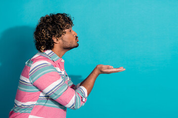 Profile photo of nice funny man wear trendy striped clothes send kiss empty space isolated on cyan...