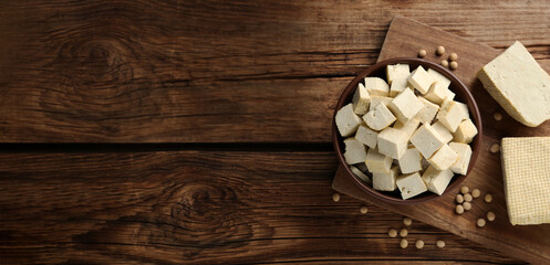 Delicious tofu and soybeans on wooden table, top view with space for text. Banner design