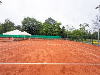 Naklejka premium Looking down the nets across the many tennis courts wet after a rain shower 
