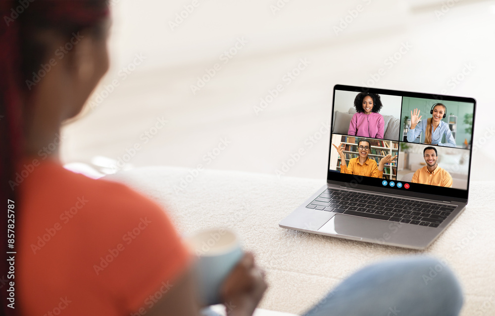 Poster a woman sits on a couch with a laptop in front of her, attending a virtual meeting with four other p