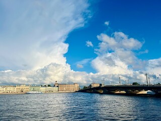 Fototapeta premium Fantastic white clouds at the city river, city river view, summer day