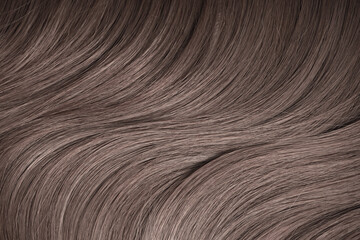 Blond hair close-up as a background. Women's long light brown hair. Beautifully styled wavy shiny...