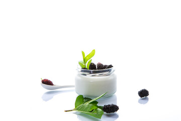 homemade sweet yogurt in a jar with black mulberries isolated on white background