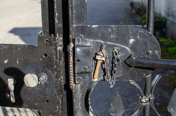 detail of the closure of a metal gate painted black
