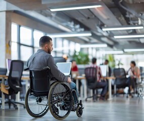 A disabled employee man in a wheelchair working with coworkers in an office.