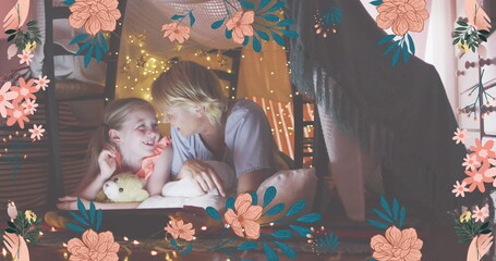 Image of flower icons over happy caucasian mother and daughter in blanket fort