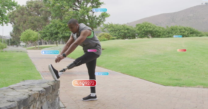 Image of social media notifications, african american man with prosthetic leg exercising in park