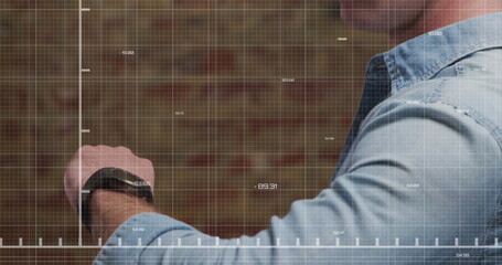 Image of stock market data processing over mid section of caucasian man using smartwatch