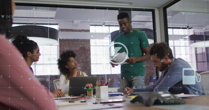 Image of digital icons against african american man talking to diverse colleagues at office
