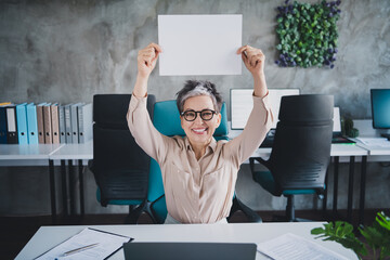 Photo of attractive good mood age lady agent dressed formal shirt rising paper empty space indoors...
