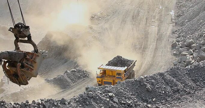 Quarry truck driving on the road in deep quarry. A large mining truck transports ore. Dumper.