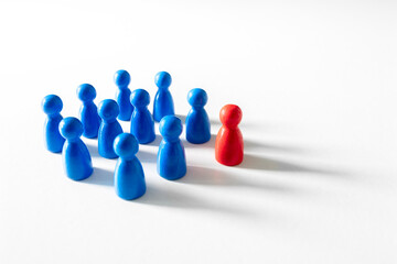 Leadership blue wooden business team with one red pawn person standing out from the crowd