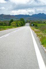 straight road into the mountains on a cloudy day