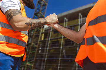 Contractor. construction worker team hands shaking after plan project contract  at construction...