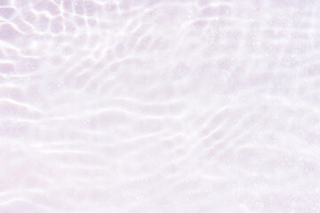 White water with ripples on the surface. Defocus blurred transparent white colored clear calm water surface texture with splashes and bubbles. Water waves with shining pattern texture background.