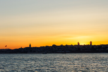 Naklejka premium Yellowish sky at the sunset over İstanbul near Bosphorus and Turkish flag
