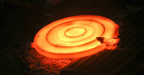 Press for forging glowing metal discs, sewer manholes isolated on black background.