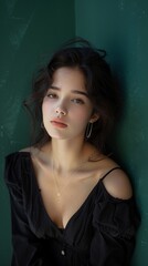 Naklejka premium Elegant Woman in Half Body Portrait on Emerald Green Background with Natural Light