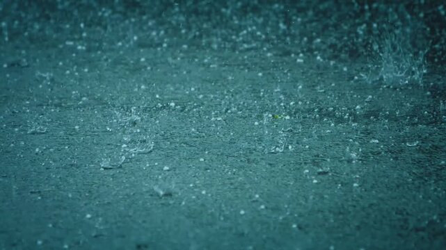 Spectacular summer hailstorm. Hailstones falling in a rain puddle