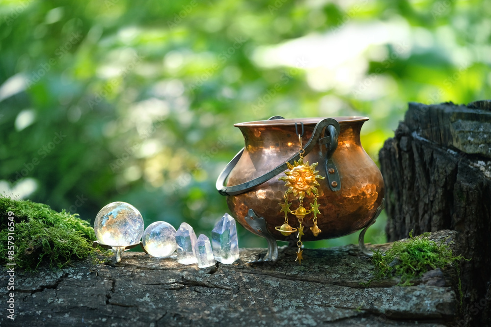 Wall mural witch cauldron with sun amulet, crystal balls and towers in forest, abstract natural background. mag