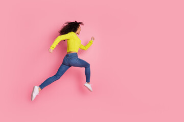 Full body photo of sporty youth funny girl wearing green sweater and jeans running with strong motivation isolated on pink color background