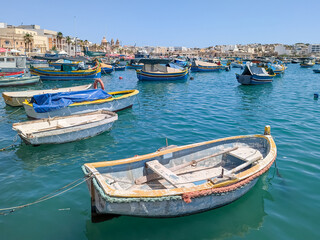 Traditional fishing colorful boats Luzzu in Marsaxlokk harbor at sunny day. Malta.
