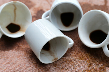 Coffee spilled from white cups on the carpet