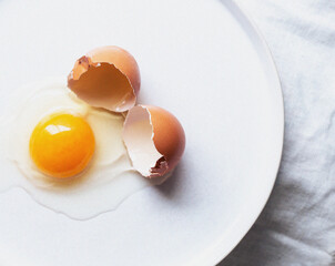 Broken eggs on white plate