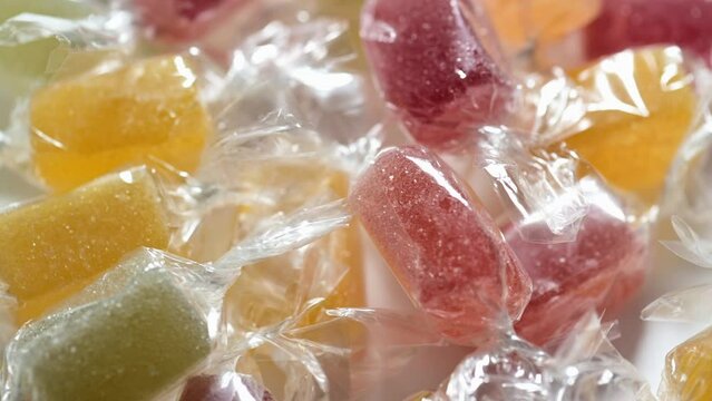 Assorted wrapped jelly candies close up with rotation.