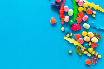 Colorful lollipops and different gummies jelly and candies, top view