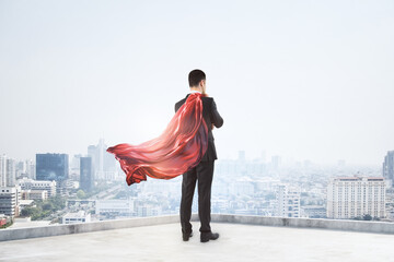 A businessman with a red cape standing on a rooftop, overlooking a cityscape, symbolizing power and leadership. Generative AI