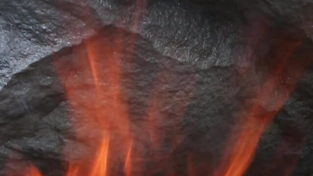 Wood is burning in the fireplace. Fire in the oven. The burning logs. Furnace heating. A fire burns in a fireplace. Christmas Holidays Concept. Video for Meditation Vertical video
