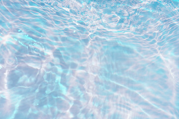 Obraz premium Blue water with ripples on the surface. Defocus blurred transparent blue colored clear calm water surface texture with splashes and bubbles. Water waves with shining pattern texture background.