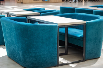 A row of blue chairs and tables arranged in a room