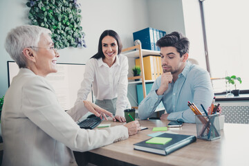 Fototapeta premium Photo of two employees mature boss woman signing contract minded collaborating new project office working together in modern workspace