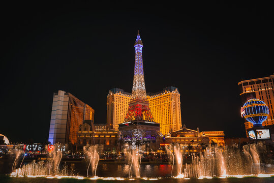 Vibrant night scene on Las Vegas Strip with illuminated Eiffel Tower replica at Paris Las Vegas Hotel, fountains, and colorful lights. Ideal for Las Vegas travel content.