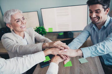 Photo of business people put hands together doing teambuilding training in workstation workplace