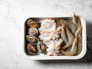 Raw octopus, abalone, and shrimp on a plate