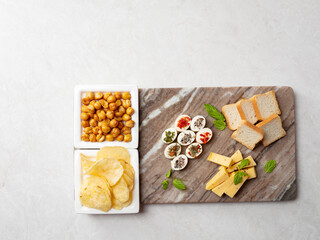 Various cheeses and snacks on a stone plate