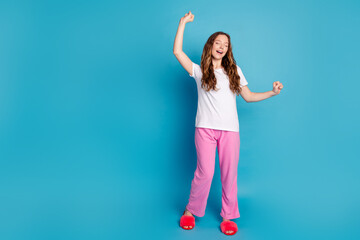 Naklejka premium Photo of nice lovely cute girl wear stylish pajama raise hands empty space isolated on blue color background