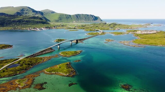 Fredvang bridge, Lofoten, Norway, summer day, bright sunshine, turquoise waters. 4k aerial view